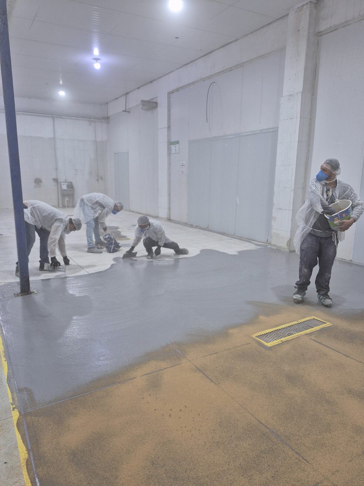 Equipe da Pavcon espalhando a argamassa de uretano autonivelante